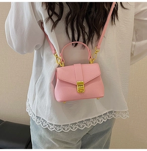 Detailed back view of model wearing pink pebbled leather mini crossbody bag with gold lock
