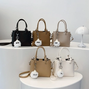 Vintage bucket bag with knot handle and plush charm shown in five stylish colors