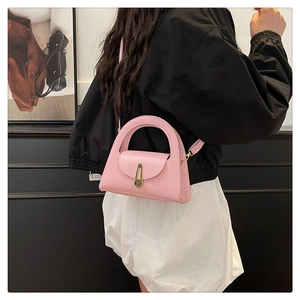 Pink semi-circle mini handbag with golden metal clasp and adjustable leather shoulder strap