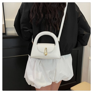 Detail of a white semicircular handbag with a gold teardrop metal lock and smooth leather