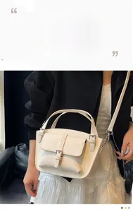 Detail of white litchi pattern leather bucket bag with silver buckle and smooth stitching