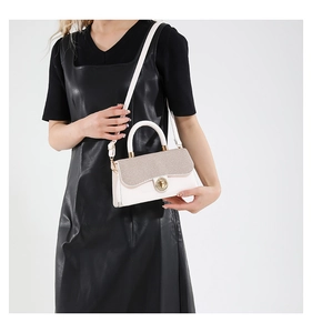 Close-up of a white mini handbag with beige woven flap and gold circular lock