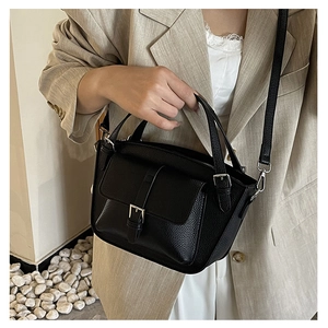 Detail of black lychee texture bucket bag featuring silver hardware and top handle
