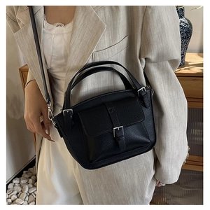 Close-up of black litchi pattern leather bucket bag showing silver hardware and strap