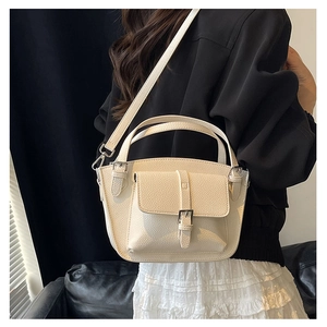 Detail of apricot bucket bag with lychee pattern texture and silver buckle pocket