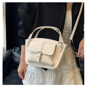Detail of white lychee pattern bucket bag with adjustable strap on leather seat
