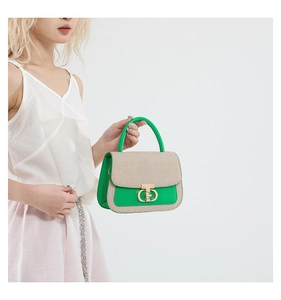 Detail of contrast color crossbody bag with green leather, straw weave and gold buckle