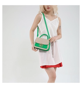 Detail of green leather and beige woven texture bag with gold double-ring lock