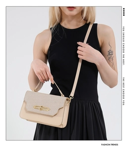 Detail of beige contrast handbag featuring woven texture and gold rectangular buckle