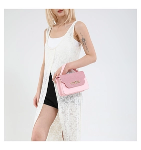 Detail of pink patchwork crossbody bag with vintage gold buckle and glitter texture flap