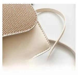 Detail of woven fabric texture and premium beige leather stitching on crossbody bag