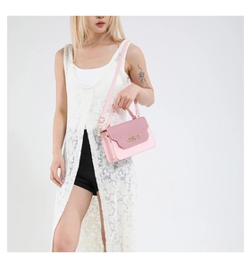 Detailed view of pink crossbody bag featuring a glitter flap and golden metallic clasp