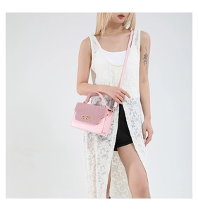Detail of pink PU leather handbag with woven texture flap and gold metal buckle lock