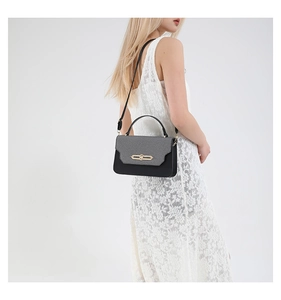 Detail of a contrast color PU leather handbag with gold metal lock and woven texture flap