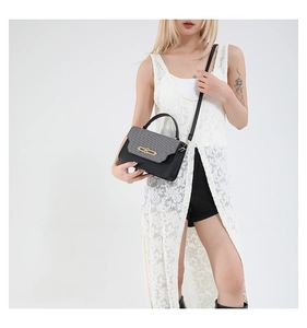 Model wearing a stylish contrast patchwork crossbody bag with gold metallic clasp