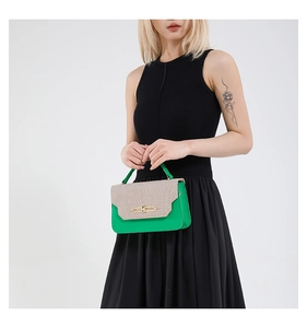 Detail view of the green leather and woven khaki flap with a golden metallic buckle