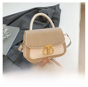 Detail of a beige leather and woven fabric crossbody bag with a round golden CD clasp