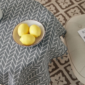 Close-up of grey herringbone cotton linen tablecloth with decorative tassel edge details