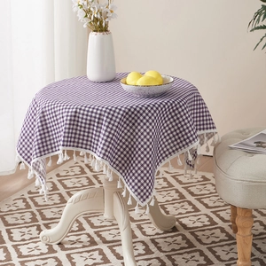 Detailed view of purple checkered linen tablecloth with white cotton tassel edge