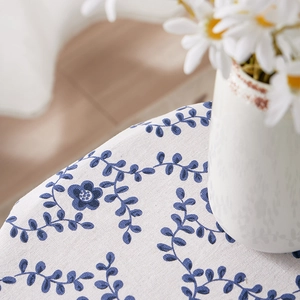 Close-up of floral cotton linen tablecloth with blue flower patterns and woven texture