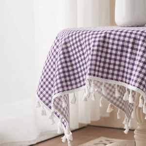 Purple and white checkered cotton linen tablecloth with elegant white tassels on a table