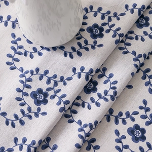Close-up of blue floral cotton linen tablecloth with heavy drape and natural texture
