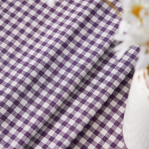Detail of purple plaid cotton linen fabric with soft texture and daisy decoration