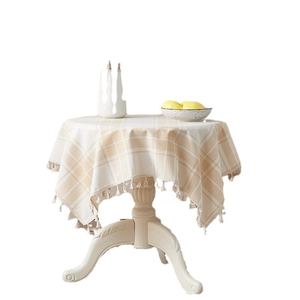 Beige and white plaid round cotton linen tablecloth with elegant fringe tassels on round table