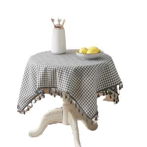 Gray plaid cotton linen tablecloth with ball tassel trim on a white vintage round table