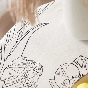 Detail of tulip printed linen tablecloth showing natural fabric texture and floral pattern