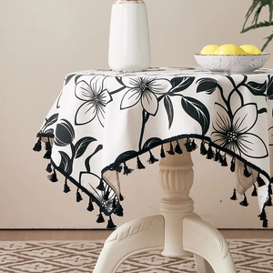 Macro view of floral pattern cotton linen tablecloth with elegant black tassel edges