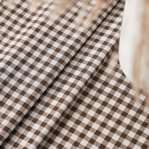 Close-up of brown and white gingham check cotton linen fabric with detailed weave texture