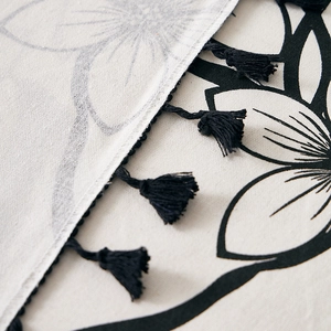 Linen table cloth with black floral patterns and handcrafted tassels for dining decor