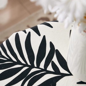 Close-up of cotton linen fabric texture with tropical black palm leaf prints on beige base