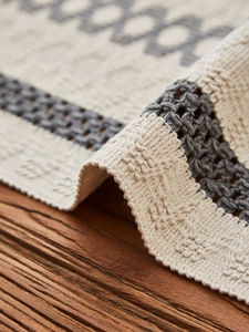 Close-up of thick hand-woven cotton table runner with gray geometric patterns