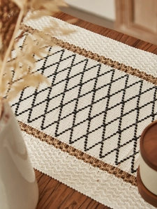 Macro detail of Nordic woven table runner featuring black diamond patterns and jute edges