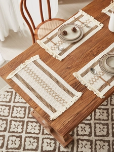 Close-up of woven cotton linen placemat with fringe details and geometric patterns