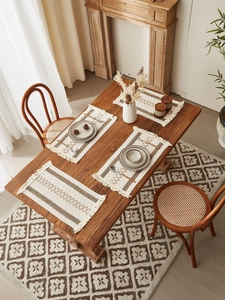 Close-up of woven cotton linen placemat with tassels and geometric brown patterns