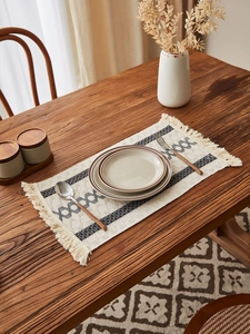 Detail of bohemian woven cotton linen table runner with fringes and geometric patterns