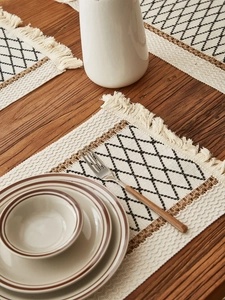 Detailed view of woven cotton linen placemat with fringe edges and diamond patterns
