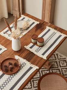 Close-up of boho cotton woven placemat with gray geometric stripes and delicate fringes