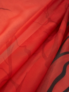Macro detail of red semi-transparent fabric with black wave patterns for Halloween decor