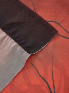 Close-up of rod pocket detail on dark red Halloween curtain with black branch pattern