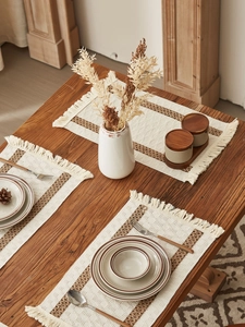 Close-up of bohemian woven cotton linen table runner with fringes and brown accents
