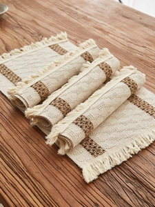 Close-up of woven cotton linen table runner with boho fringes and striped texture