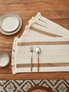 Close-up of cotton linen woven placemats with brown stripes and decorative fringe details