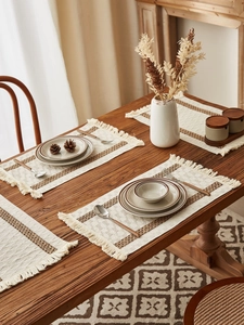 Close-up of woven table runner with retro brown pattern and handmade cotton tassels