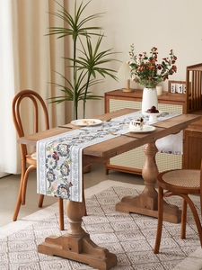 Detail of vintage mandala print table runner with tassel on dark wooden dining table