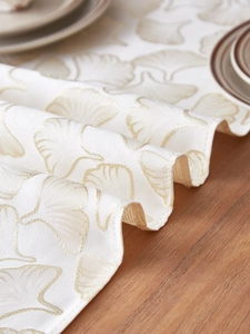 Close-up of premium ginkgo leaf jacquard embroidery on luxury cream table runner fabric