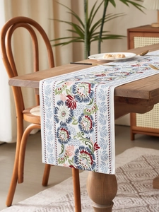 Close-up of vintage floral print table runner with intricate botanical patterns on wood
